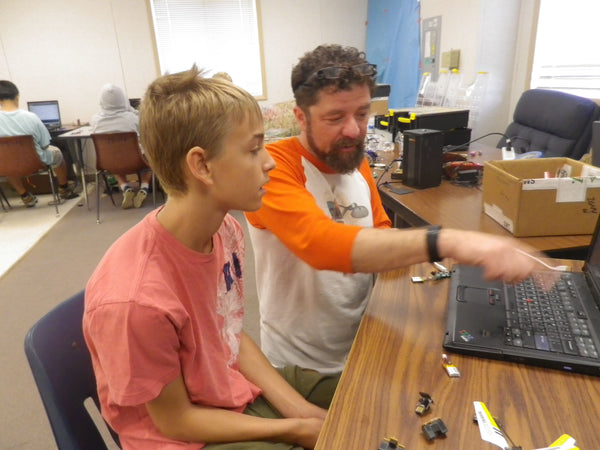 dr. george albercook works with a young man at rocks and robots summer camp